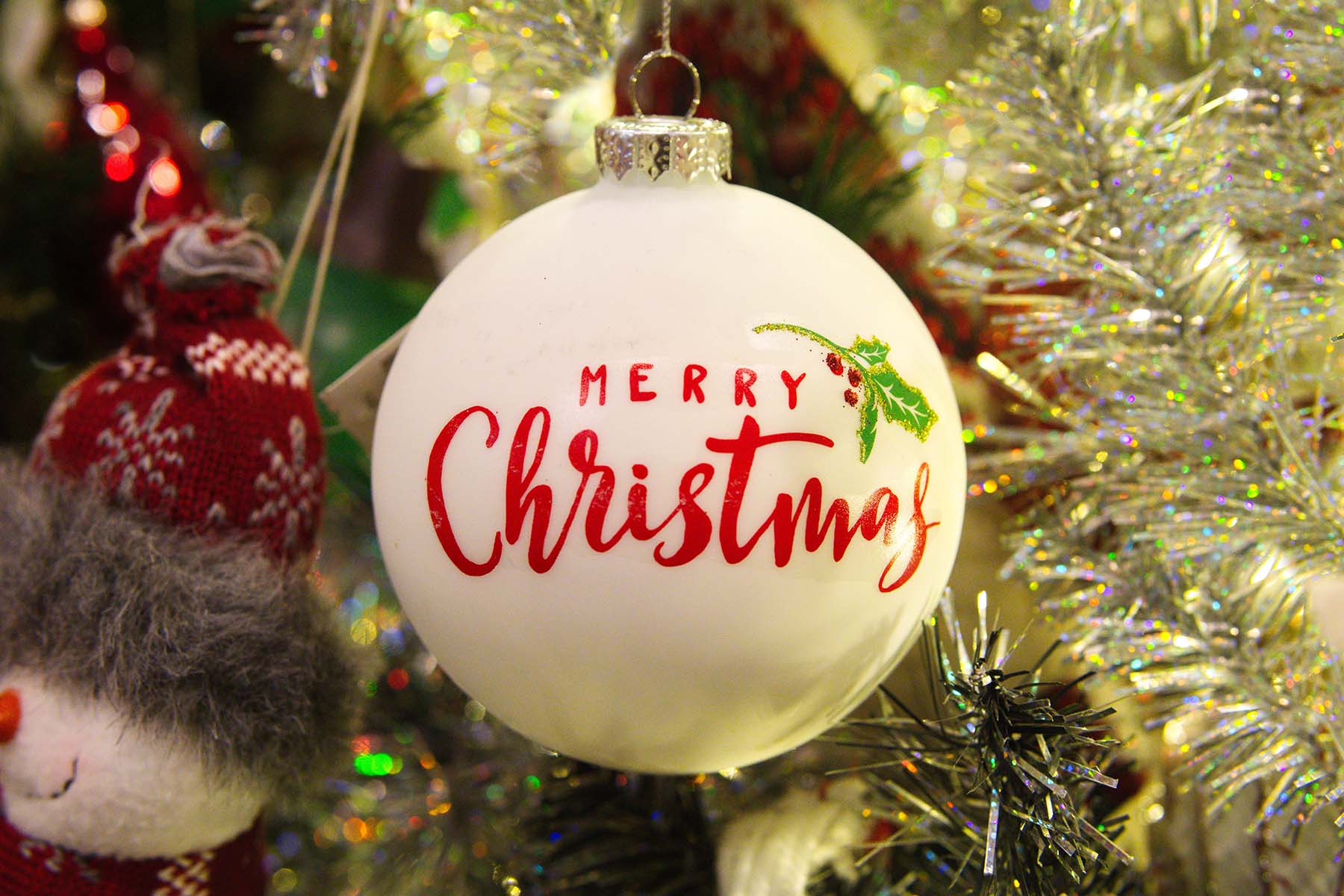 In primo piano una pallina di Natale con la scritta Merry Christmas a richiamare le attività di email marketing durante le feste di fine anno.